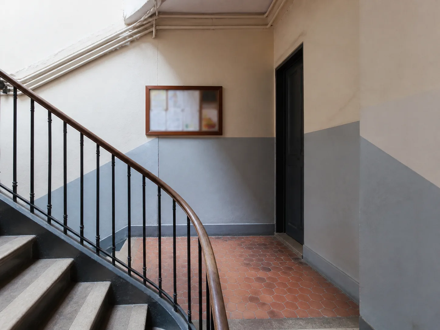 Escalier commun aux murs bicolores et au sol en tomettes