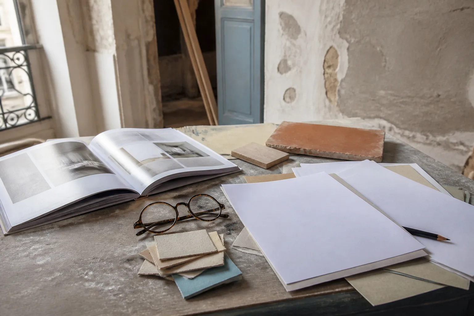 Livre de référence, feuilles vierges, lunettes et échantillons sur un bureau